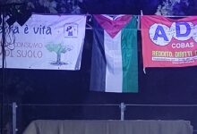 Striscioni appesi sopra il palco di Ekopark a Monselice: «La terra è vita, no consumo di suolo» del comitato Lasciateci Respirare, una bandiera palestinese e uno striscione ADL Cobas, 7 settembre 2026