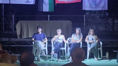 Quattro relatori seduti sul palco all’aperto di Ekopark a Monselice, con una cagnolina galgo sdraiata ai loro piedi e lo striscione Lasciateci Respirare alle spalle, 7 settembre 2026