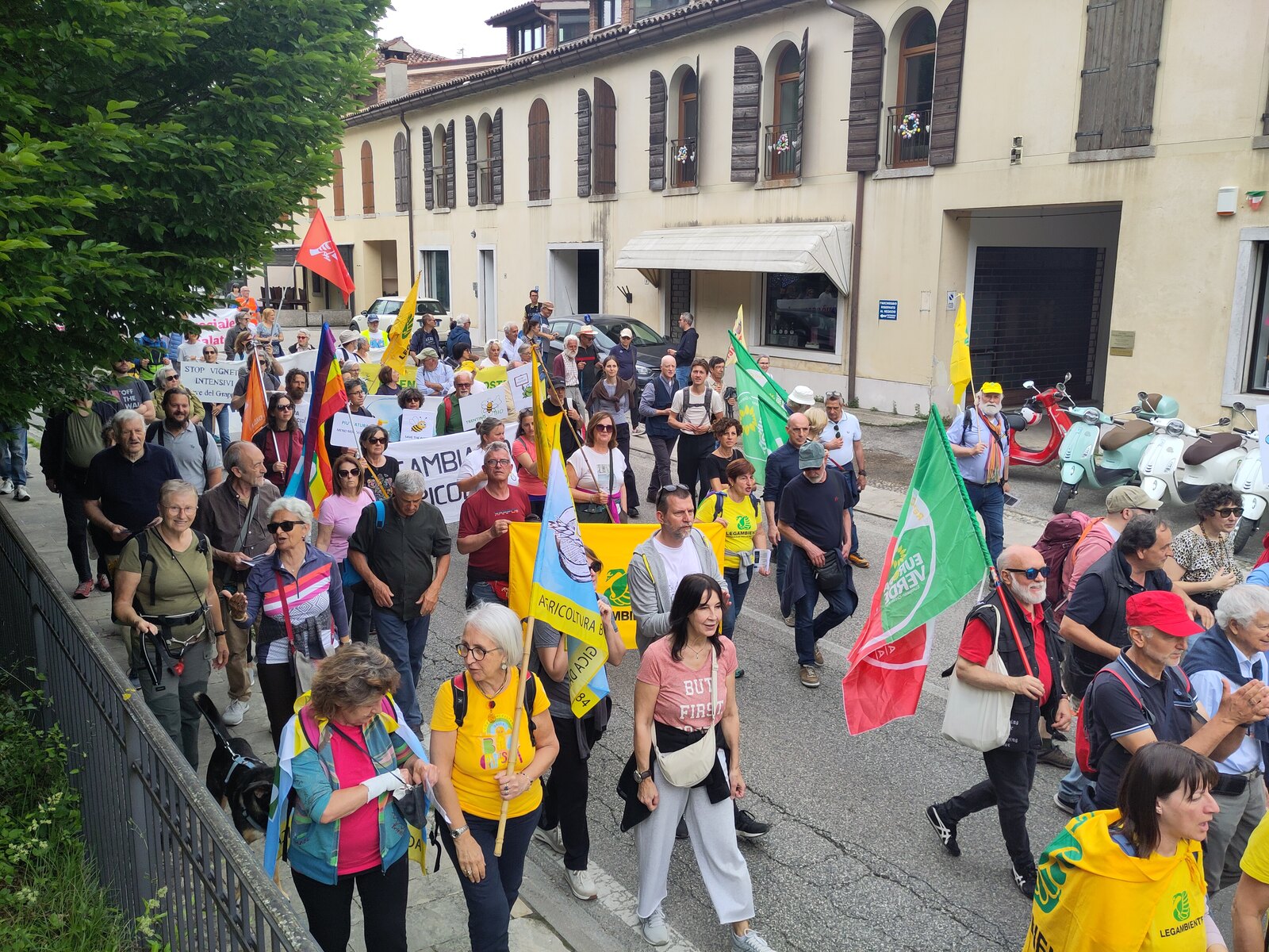 L'arrivo del corteo della decima Marcia Stop Pesticidi all'Abbazia di Follina con striscione Cambiamo Agricoltura e bandiere FederBio