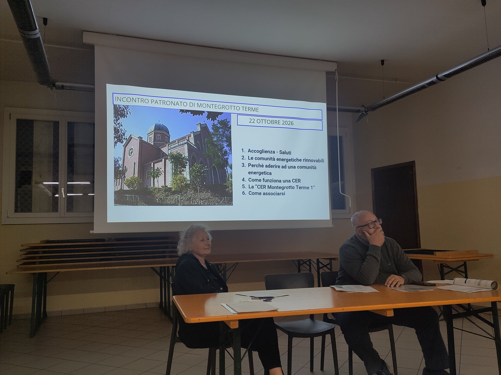 Serata informativa della CER Montegrotto Terme 1 al Patronato San Pietro, 22 ottobre 2026: due relatori al tavolo davanti alla slide con il programma